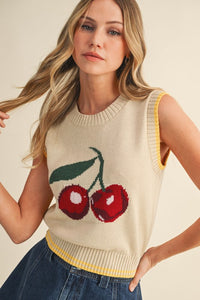 Bring a playful pop to your wardrobe with this sleeveless knit vest featuring a bold cherry graphic.

Designed in a soft beige tone with contrast yellow trim, this retro-inspired piece is perfect for pairing with denim or layering over your favorite shirt for a fun, casual look.